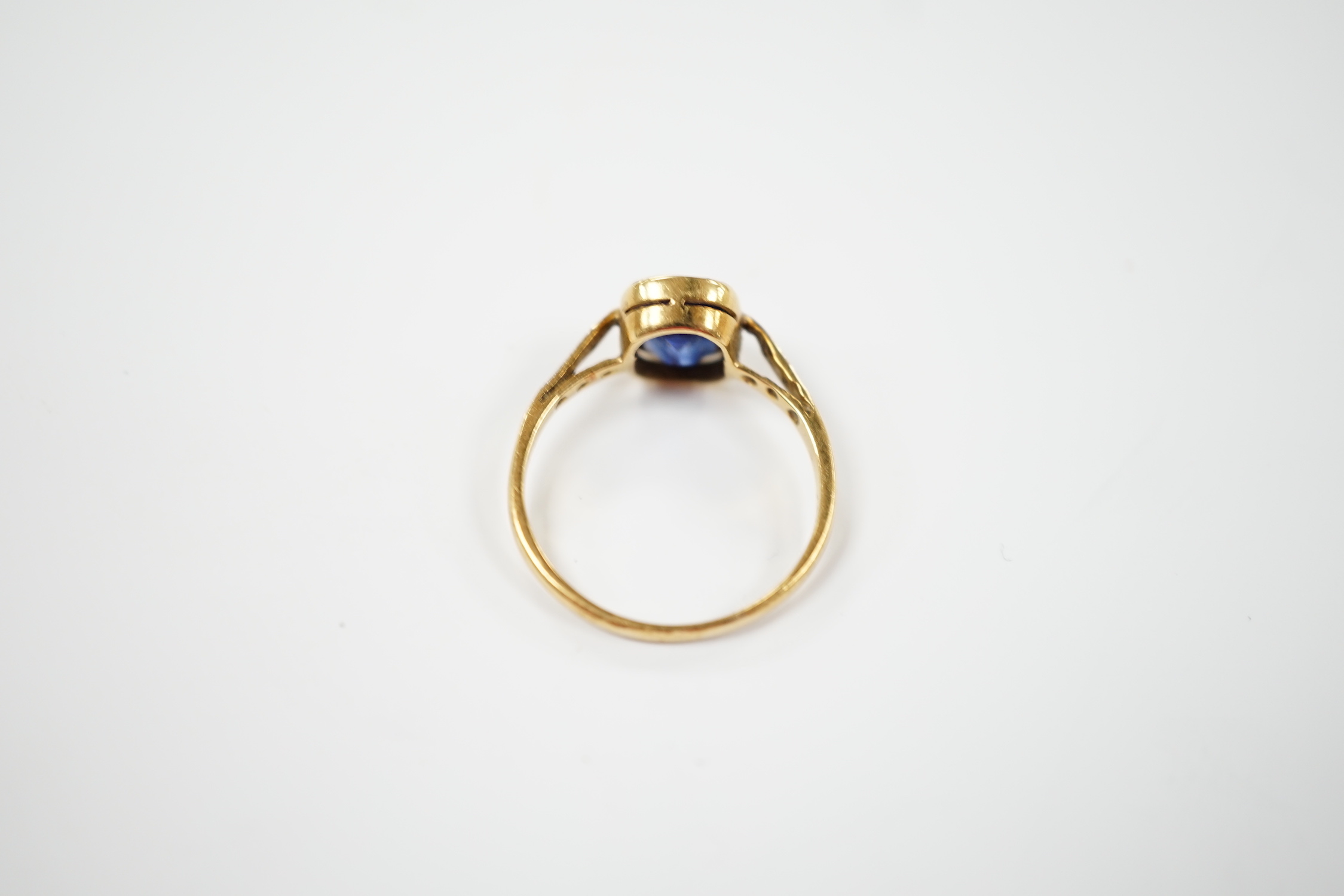 A yellow metal and single stone synthetic sapphire set ring, with rose cut diamond chip set shoulders(three stones missing),size N, gross weight 2.7 grams.